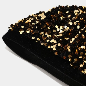 Detailed macro view of gold sequins on premium black velvet fashion beret hat surface