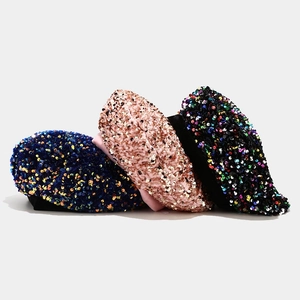 Detailed close-up of sequined berets in navy, pink, and black with shiny reflective texture
