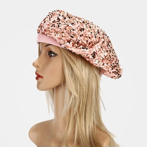 Close-up of pink gold sequins on a stylish beret hat with shimmering scale-like details