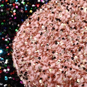 Detail of pink velvet fabric with gold sequins and black multi-color sequined texture