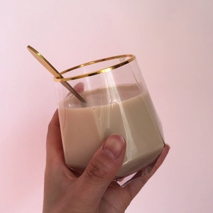 Detailed view of polygon glass cup with gold rim and golden spoon for coffee