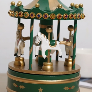 Détail d'un carrousel musical vintage vert et doré avec chevaux blancs et cristaux