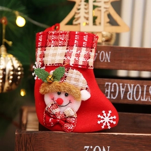 Detail of red Christmas stocking with snowman design and festive plaid patterns