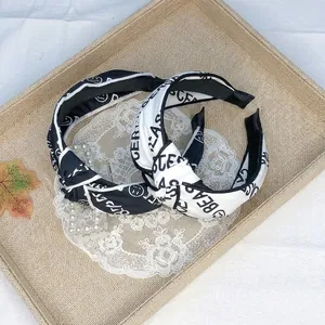 Close-up of black and white letter print knotted headbands with 40x5cm size specifications