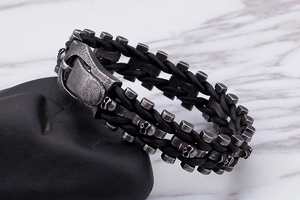 Détail d'un bracelet punk en cuir tressé avec breloques crâne en argent vieilli sur pierre
