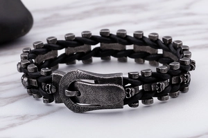 Close-up of a skull buckle on a braided leather punk bracelet with vintage finish