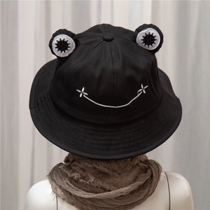 Cute black frog-shaped bucket hat with 3D eyes and smile embroidery on a model
