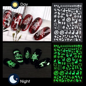 Luminous Christmas nail stickers featuring snowflakes and Santa with green glow effect