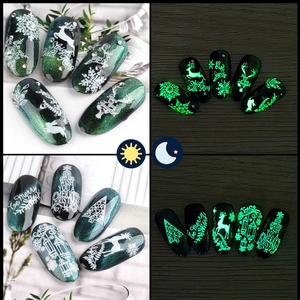 Macro view of Christmas nail stickers with luminous snowflake patterns glowing in the dark