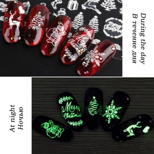 Macro comparison showing Christmas nail stickers with glow-in-the-dark effect and reindeer patterns