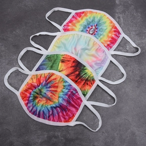 Set of four colorful tie-dye print face masks with ear loops on grey background