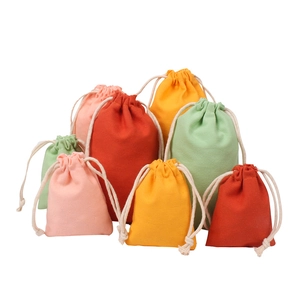 Detailed view of colorful drawstring cotton pouches in various sizes for gift storage
