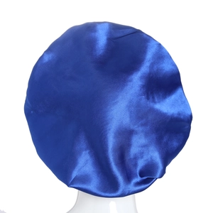 Detailed view of glossy royal blue satin sleep cap on a mannequin for hair protection