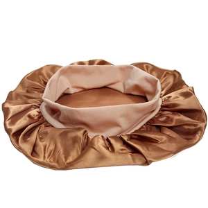 Close-up of golden satin sleeping cap showing smooth silk texture and elastic wide band