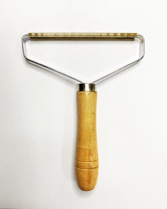 Close-up of portable lint remover with wooden handle and pure copper double-sided blade