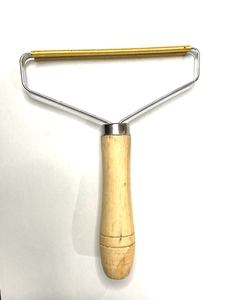 Macro detail of the dual copper lint scraper teeth and durable stainless steel frame
