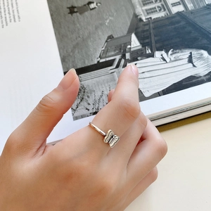 Detailed view of an adjustable sterling silver butterfly ring worn on a finger