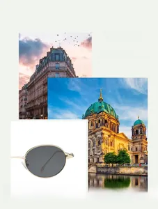 Detail view of oval metal sunglasses with gold frame and dark lenses against a scenic backdrop