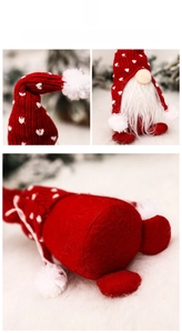 Detail of Christmas gnome with red knitted hat, white heart embroidery and long beard