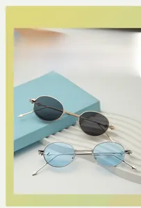 Oval metal sunglasses in gold and silver frames with dark and blue lenses on display