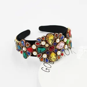 Close-up of baroque velvet headband with colorful rhinestones and imitation pearls