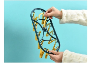 Detail of multi-clip plastic drying rack with 12 clips held by hand for small garments
