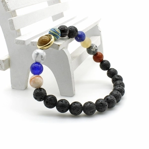 Macro detail of solar system stone bracelet with lava beads on a white mini wooden bench