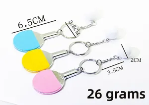 Detailed size view of mini ping pong racket keychains in blue, yellow, and pink colors