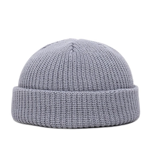 Detailed view of the grey knitted texture and rolled edge of the brimless docker cap
