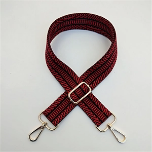 Close-up of adjustable red and black ethnic pattern bag strap with gold metal hardware