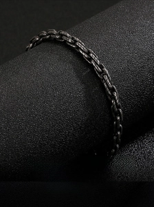 Makroaufnahme eines schweren Metall-Gliederarmbands im Hip-Hop-Stil auf Lederständer