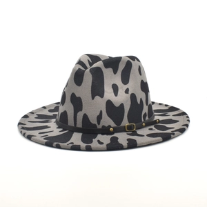 Détail d'un fedora en laine imprimé vache gris avec ruban en cuir brun et boucles en métal