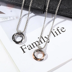 Three-ring interlocking pendant necklace in stainless steel on a white magazine background