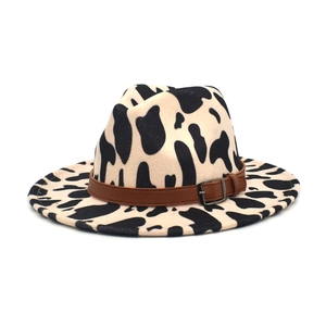 Detail of cow print wool fedora featuring a dark brown leather band and metal buckle