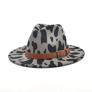 Detail of grey cow print fedora wool hat with brown leather belt and metal buckle