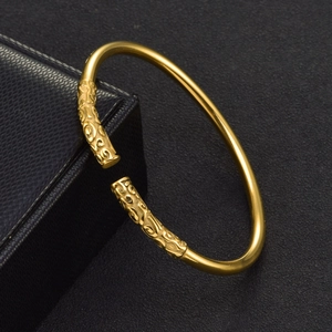 Vintage golden Sun Wukong staff open bangle with cloud engravings on black jewelry box