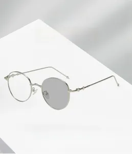 Detail showing photochromic lenses transitioning from clear to dark in metal round frames