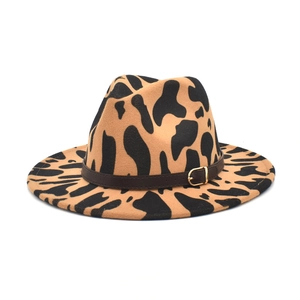 Detail of wool fedora hat with cow print pattern and leather belt featuring golden buckle