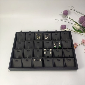 Detailed top view of a black 24-compartment jewelry tray displaying necklaces and earrings