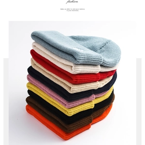 Variety of colorful knitted beanies stacked together for winter warmth and outdoor fashion