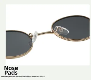 Close-up of adjustable clear silicone nose pads on gold metal oval sunglasses