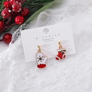 Detail of asymmetric Christmas earrings with red glove and sock designs on display card