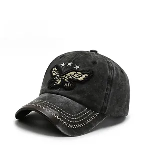 Detail of embroidered eagle and stars on vintage washed denim baseball cap with leather trim