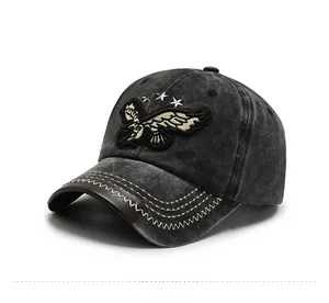 Detailed close-up of eagle embroidery and stars on vintage washed black denim baseball cap