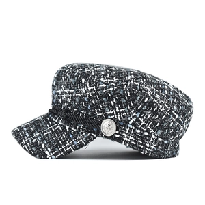 Detail of tweed sailor cap featuring woven rope trim and silver anchor metal buttons