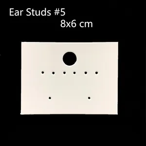 Detailed view of white earring display cards in 8x6cm size on a dark background