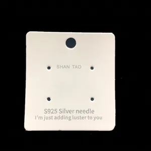 Macro detail of white jewelry earring display card measuring 6.7x6.2 cm with four holes