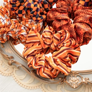 Detail of Halloween velvet scrunchies with spider web and plaid patterns on lace