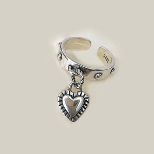 Detailed close-up of S925 silver ring with heart pendant and rivet ornaments