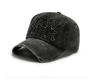 Detailed side view of washed black denim baseball cap with New York embroidery and distressed brim